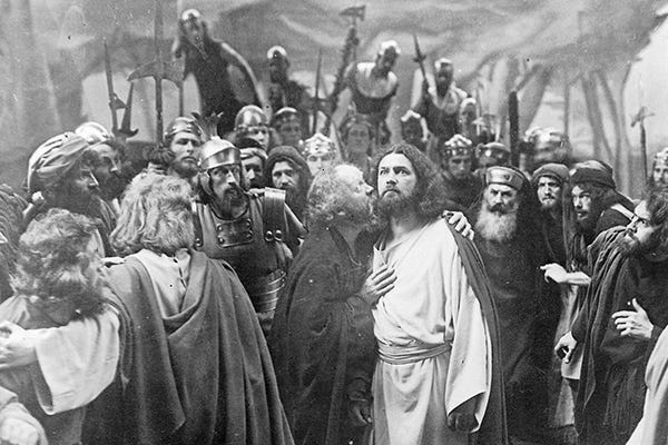 Black and white photo of passion play, Judas Kiss, everyone looks scraggly and serious